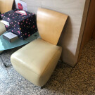 Sillon de piel sin brazos y tapizado blanco, con respaldo de madera